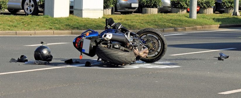 Motorcycle Laying On The Road After An Accident Next To A Drivers Helmet