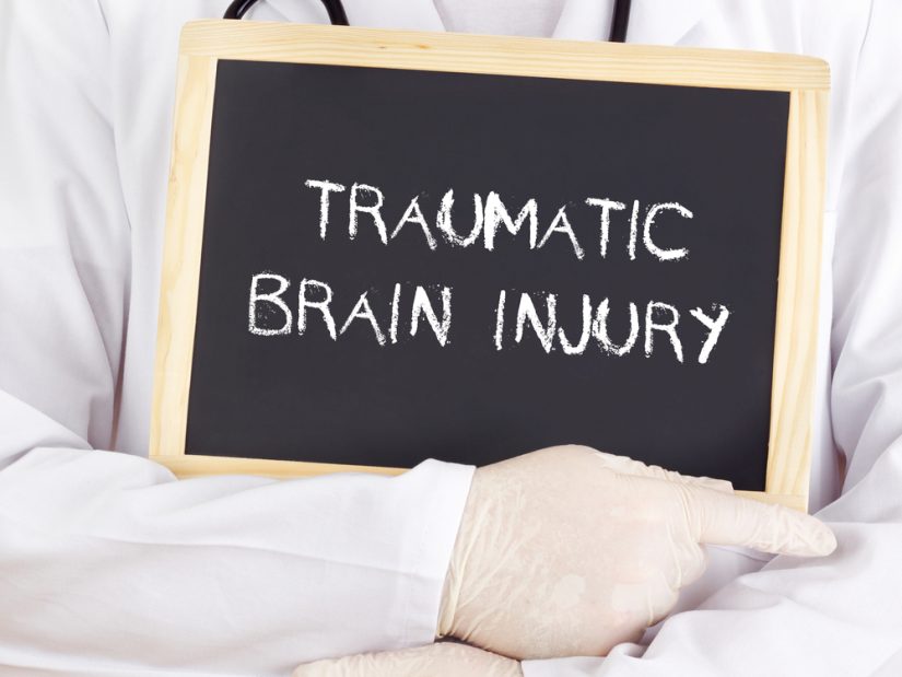 Person Holding Traumatic Brain Injury Written On A Tablet