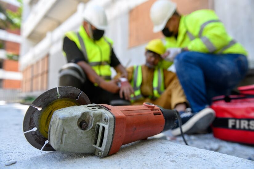 Angle Grinder Laying On The Floor With Workers In The Background