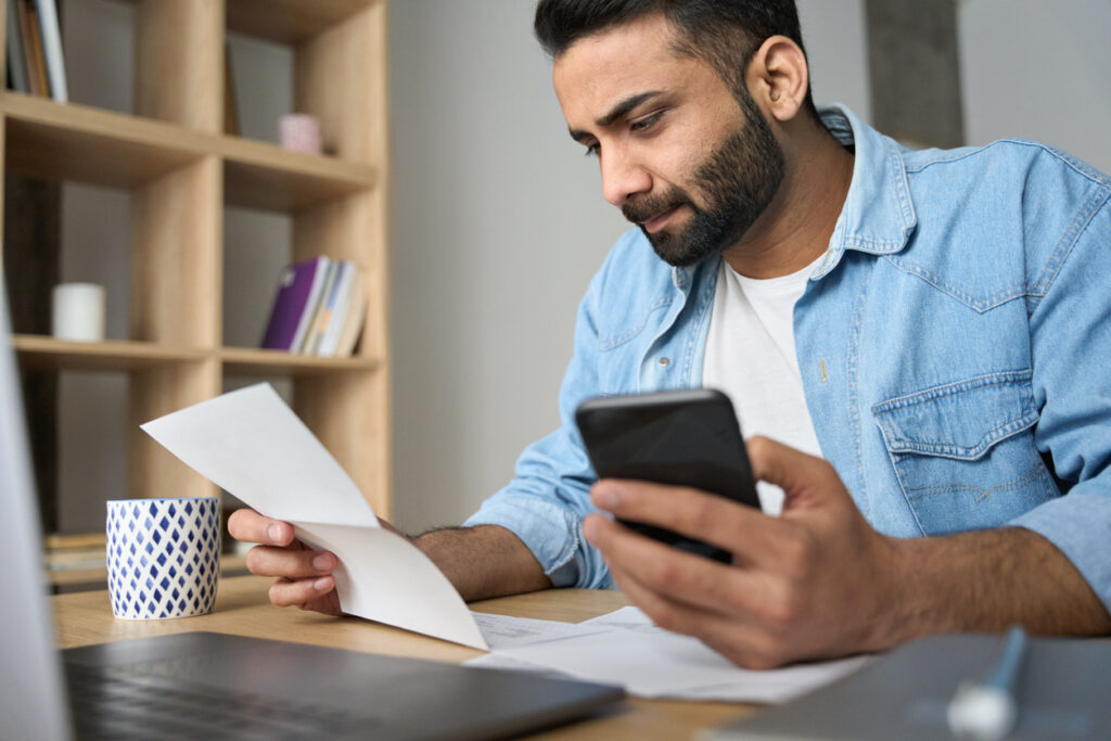 A man reviews his bills with a calculator in hand