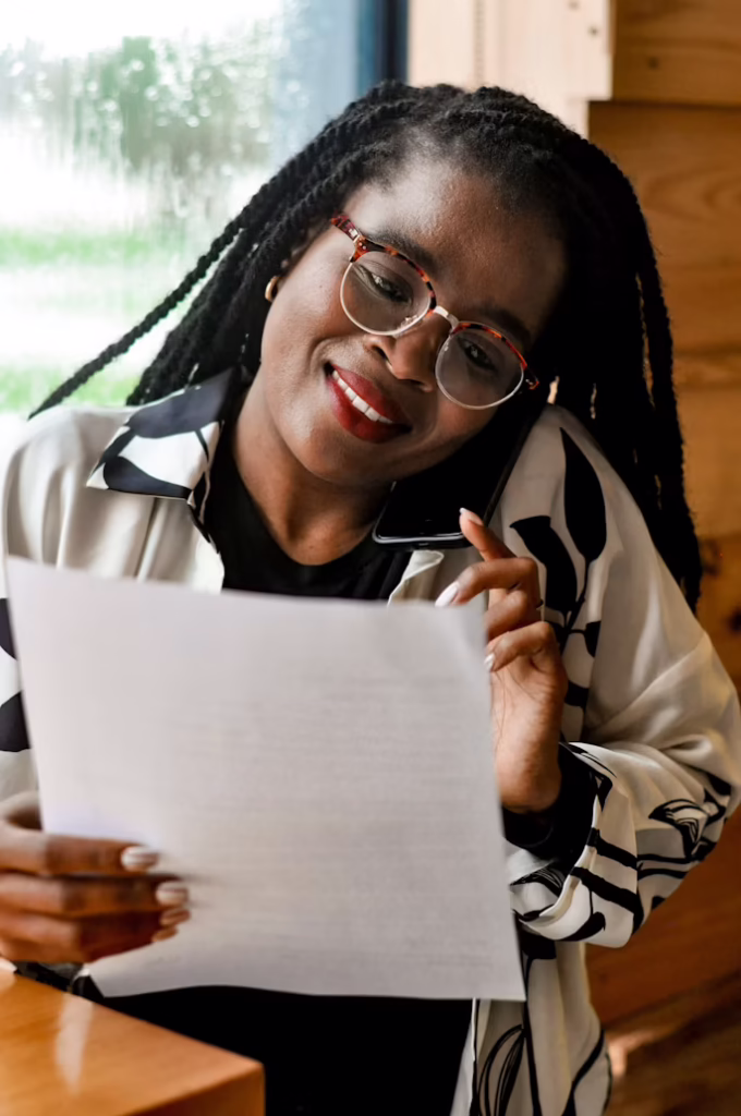 A Business Woman Looking At Paperwork While On The Phone