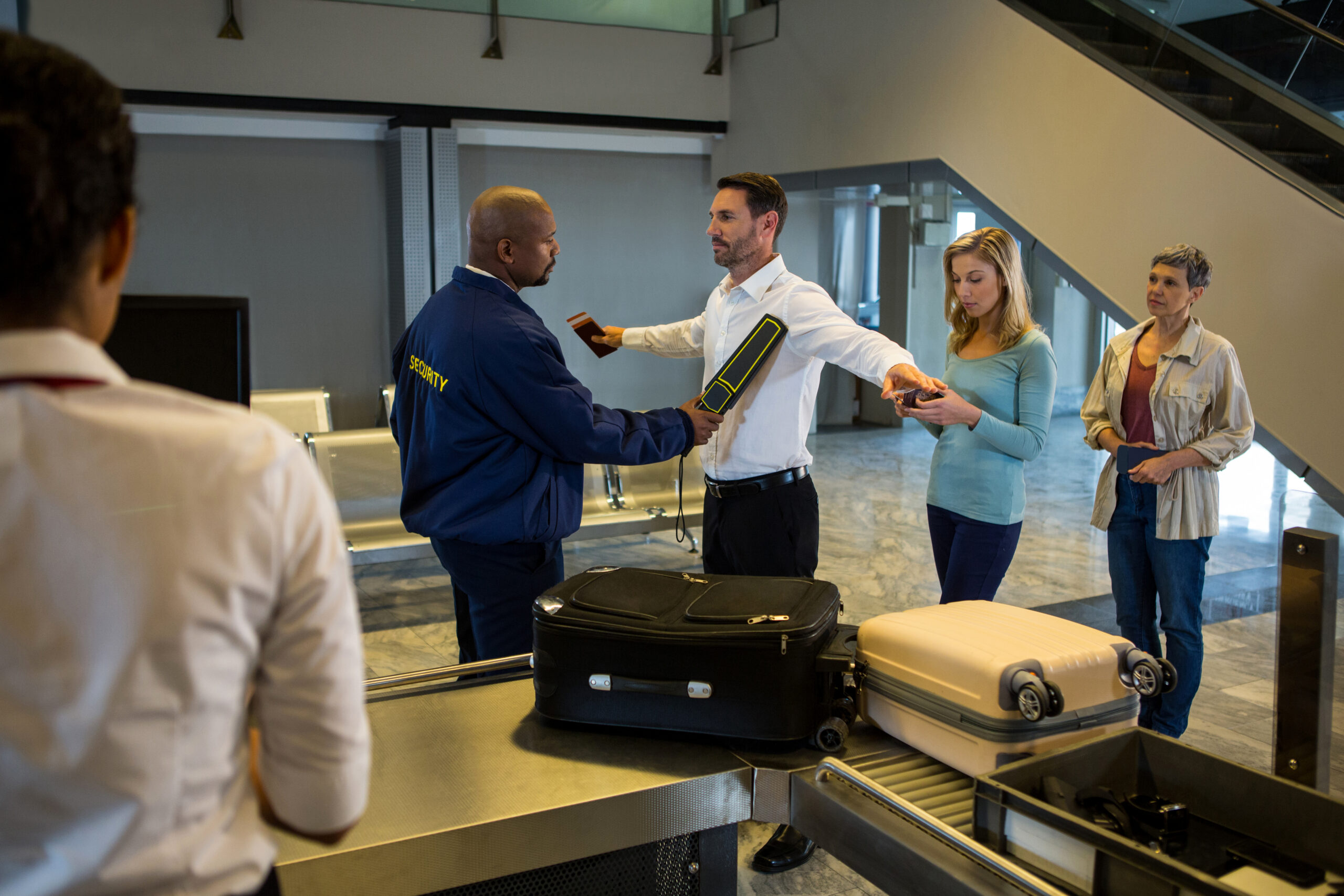 Security Guard Frisk Passengers Standing In Queue